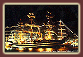 A tall ship lit up in the nighttime.